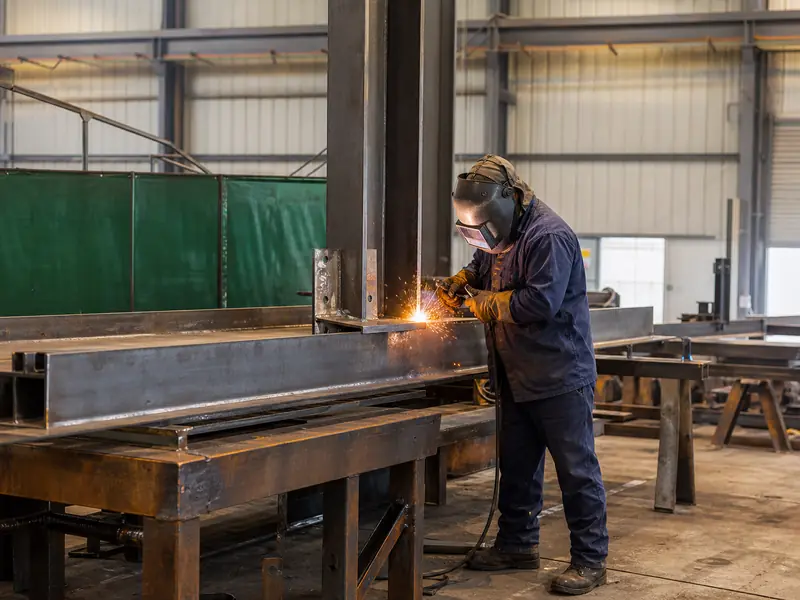 Structural steel welding operation in a fabrication workshop