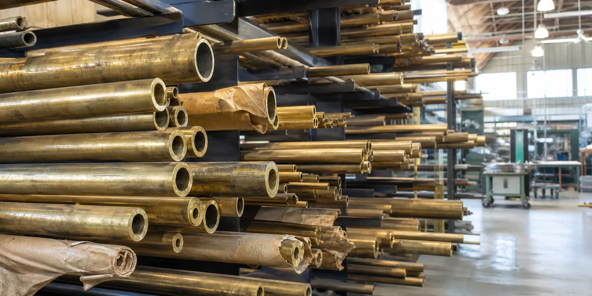 Yellow brass tubes of mixed diameters stored in workshop cantilever racks